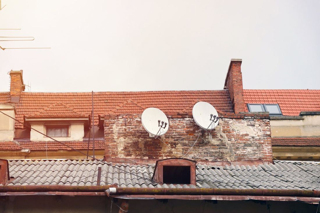 Zewnętrzna antena internetowa na szczycie starego ceglanego domu